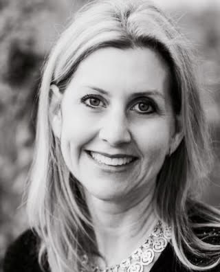 A black and white photo of a woman smiling.
